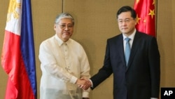 Bộ trưởng Ngoại giao Trung Quốc Tần Cương (phải) và Bộ trưởng Ngoại giao Philippines Enrique Manalo bắt tay trong buổi lễ chào mừng trước cuộc gặp song phương tại khách sạn Diamond, ngày 22 tháng 4 năm 2023, tại Manila, Philippines. 