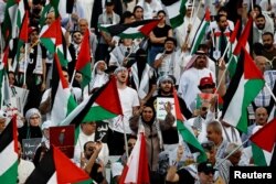 بحرین میں ہونے والے احتجاج میں لوگوں نے فلسطینی پرچم تھامے ہوئے ہیں۔