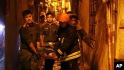 Lực lượng cứu hộ khiêng một người trên cáng ra khỏi tòa nhà đang cháy ở Hà Nội vào ngày 13/9/2023.