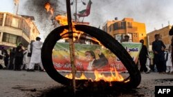 پاکستان تحریک انصاف (پی ٹی آئی) کے کارکن 21 اکتوبر 2022 کو کوئٹہ کی ایک سڑک پر سابق وزیراعظم عمران خان کی نااہلی کے فیصلے کے خلاف ٹائر جلا کر احتجاج کر رہے ہیں۔فوٹو 