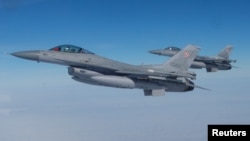 فائل فوٹو: امریکی F-16 طیارے 21 مارچ 2023 کو مالبورک، پولینڈ میں نیٹو میڈیا ایونٹ کے دوران پرواز کر رہے ہیں