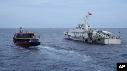 TƯ LIỆU - Một tàu tiếp tế của Philippines (trái) cố gắng tránh một tàu hải cảnh của Trung Quốc ngoài khơi Bãi cạn Second Thomas, ở vùng Biển Đông có tranh chấp trong một nhiệm vụ luân chuyển và tiếp tế, ngày 22 tháng 8 năm 2023.
