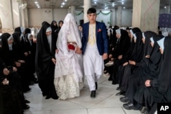 افغانستان میں شادی کی ایک اجتماعی تقریب میں ایک دولہا اور دلہن ، فوٹو اے پی 8 مارچ 2023