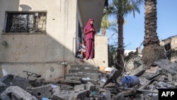 Một phụ nữ Palestine xem ngôi nhà của gia đình cô bị phá hủy ở Nuseirat sau vụ ném bom của Israel qua đêm ngày 23/5. Israel nói họ tìm thấy thi thể của 3 con tin bị bắt giữ trong vụ đột kích này.