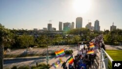 فلوریڈا کی ریپبلکن زیرقیادت مقننہ کے منظور کردہ متنازعہ "ہم جنس پرست مت کہو" بل کے خلاف احتجاج کے دوران 12 لوگ مارچ 2022 کو سینٹ پیٹرزبرگ، فلوریڈا میں سینٹ پیٹ پیئر کی طرف مارچ کر رہے ہیں۔ اے پی فوٹو