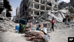  غزہ کی پٹی کے علاقے خان یونس میں فلسطینی اسرائیلی کارروائی سے تباہ شدہ اپنے گھروں کے ملبے پر ۔ فوٹو اے پی 6 مارچ 2024