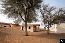 بیس سال قبل دوبئی میں بدووں کی مستقل سکونت کے لیے بنائے گئے مکانات پر مشتمل گاؤں جو اب ریت میں دبا ہے ۔فوٹو اے پی، 9 جولائی 2023
