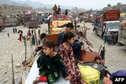 افغان پناہ گزین بچے اپنے ساز و سامان کے ساتھ ٹرکوں پر سوار افغانستان واپسی کے سفر پر پاکستان افغانستان کی طورخم سرحد پر ، فوٹو اے پی یکم نومبر 2023