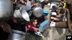 رفح میں اسرائیل کے فضائی اور زمینی حملوں کے دوران بے گھر فلسطینی نو جنوری کو خوراک کے لئے قطاروں میں کھڑے ہیں ۔اے پی فوٹو
