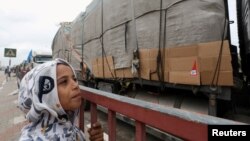 ایک فلسطینی بچہ شمالی غزہ جانے والے امدادی ٹرک کو دیکھ رہا ہے۔فوٹو رائٹرز