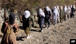 دسمبر 2011 کی اس تصویر میں پاکستانی طالبان ماسک پہن کر چھاپہ مار حملوں کی تربیت حاصل کر رہے ہیں۔