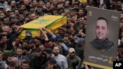 حزب اللہ کے جنگجو، اپریل 2024 کو اپنے ایک کمانڈر علی احمد حسین کے جنازے کے جلوس میں، جو جنوبی لبنان میں اسرائیلی حملے میں مارے گئے تھے۔ فوٹو اے پی