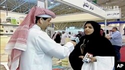 سعودی عرب کے سرکاری ٹیلی ویژن کی ایک فوٹیج جس میں طالبہ اور خواتین کے حقوق کی سرگرم کارکن سلمہ الشہاب ایک کتاب میلے صحافی سے گفتگو کر رہی ہیں۔ ( مارچ 2014۔اے ایف پی)