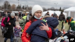 Một người phụ nữ bế con khi tới biên giới Medyka với Ba Lan hôm 28/2 sau khi chạy khỏi Ukraine. Việt Nam đang chuẩn bị cho kế hoạch đưa công dân về nước trong lúc tình hình chiến sự ở Ukraine ngày càng xấu đi.
