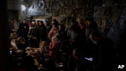 Người dân tụ tập trong một tầng hầm, được sử dụng làm hầm trú bom, trong một cuộc không kích ở Lviv, tây Ukraine, ngày 19 tháng 3 năm 2022. (Ảnh AP / Bernat Armangue)