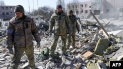 Binh sĩ Ukraine tìm kiếm thi thể trong đống đổ nát của một trường quân sự bị phi đạn của Nga bắn trúng một ngày trước đó, ở Mykolaiv, miền nam Ukraine, ngày 19 tháng 3 năm 2022.