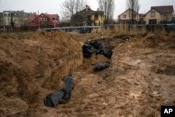 یوکرین کے علاقے کیف کے ایک مضافاتی علاقے میں ایک اجتماعی قبر، فوٹو اے پی 3 اپریل 2022