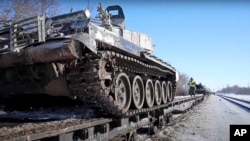 Bộ Quốc phòng Nga ngày 16/2/2022, công bố ảnh xe tăng của Nga được đưa lên xe lửa để rút về căn cứ sau khi tập trận. 