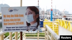 Một biển hiệu yêu cầu khách du lịch đeo khẩu trang ở Hạ Long, Quảng Ninh. Việt Nam mở cửa du lịch rộng rãi cho khách du lịch hôm 15/3 nhưng vẫn chưa đưa ra quy định cụ thể về nhập cảnh trong lúc số ca nhiễm COVID tăng cao kỷ lục.