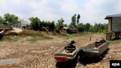 Hai chiếc xuồng nằm trên mặt đất nứt nẻ trong một vùng khô hạn tại tỉnh Cà Mau, Việt Nam. Việt Nam đang đối mặt với đợt hạn hán nghiêm trọng nhất trong 90 năm qua, theo một tuyên bố của Bộ Nông nghiệp và Phát triển Nông thôn.