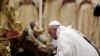 Đức Giáo hoàng Phan Xi Cô hôn vào tượng Chúa Hài Đồng Giêsu trong khi Ngài cử hành Thánh lễ Đêm Giáng inh tại Vatican hôm 24/12.