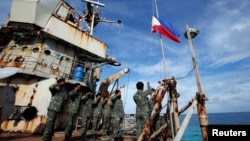 TƯ LIỆU - Thủy quân lục chiến, thành viên của một phân đội đóng quân trên tàu BRP Sierra Madre, tham gia lễ hạ cờ trên tàu, tại Bãi Cỏ Mây (Second Thomas Shoal) ở Biển Đông, ngày 29 tháng 3, 2014.