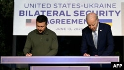 یوکرینی صدر زیلنسکی اٹلی میں صدر بائیڈن کے ساتھ سیکیورٹی کے دس سالہ معاہدےپر دستخط کرتے ہوئے، فوٹو اے پی 13 جون 2024