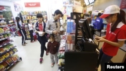 Nhân viên kiểm tra hóa đơn của khách hàng tại một siêu thị ở Hà Nội.