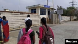 دو خواتین سریپرمبدور میں فاکسکون فیکٹری کے مرکزی دروازے پر سیکیورٹی آفس کے باہر کھڑی ہیں۔فوٹو رائٹرز
