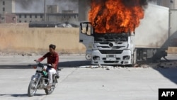 Suriyeli muhaliflerin kontrolündeki Halep'in kuzeyindeki El Bab'da, Türkiye karşıtı protestolarda araçlar da ateşe verildi- 1 Temmuz 2024 (AFP).