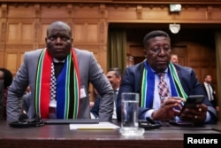 جنوبی افریقہ کے وزیر انصاف رونلڈ لاموالا اور نیدر لینڈز میں جنوبی افریقہ کے سفیر ووسیموزی بین الاقوامی عدالت میں مقدمے کی سماعت کے دوران ، فوٹو رائٹرز 12 جنوری 2024