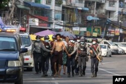 پولیس ینگون میں کریک ڈاؤن کے دوران ایک شخص کو پکڑ کر لے جا رہی ہے۔ 26 فروری 2021