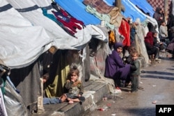 رفح میں ایک عورت اور بچے بے گھر فلسطینیوں کے خیموں کے باہر بیٹھے ہیں، فوٹو اے ایف پی ،8 فروری 2024