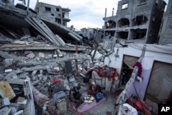 اسرائیلی حملوں میں تباہ ہونے والے ایک گھر کے افراد ملبےکے ڈھیر پر روزہ افطار کر رہے ہیں۔ 18 مارچ 2024
