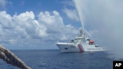 Tàu tuần duyên của Trung Quốc tiếp cận ngư dân Philippines ngoài khơi bãi cạn Scarborough trên biển Đông. Trung Quốc khống chế bãi cạn này từ 2012 tới 2016 khi Mỹ tuyên bố ngăn cản Trung Quốc làm điều này.