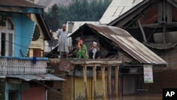 Người dân Kashmir tránh lũ trên nóc nhà kêu lớn xin giúp đỡ ở Srinagar, Ấn Độ, 9/8/2014.