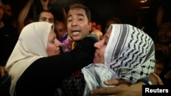 رہا ہونے والی ایک فلسطینی قیدی کو ان کی والدہ گلے لگا رہی ہیں۔