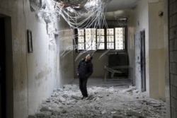 ایک تباہ شدہ گھر کے معائنے میں مصروف شامی بچہ