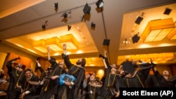 Sinh viên tung mũ trong lễ tốt nghiệp trường Kinh doanh Quốc tế Hult ở Cambridge, Massachusetts.