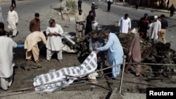 Cảnh sát nhân viên cứu hộ che thi thể nạn nhân sau vụ nổ bom ở Quetta, Pakistan, hôm 23/6. Hàng chục người thiệt mạng trong 3 vụ nổ bom cùng ngày ở Pakistan.