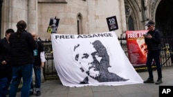 Người ủng hộ giăng biểu ngữ đòi thả tự do cho nhà sáng lập WikiLeaks, Julian Assange, bên ngoài Toà án Công lý Hoàng gia ở London hôn 23/10 trước phiên xử kháng cáo chống lại việc dẫn độ ông sang Mỹ.