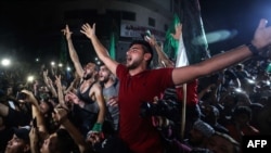 Dân chúng đổ ra đường ăn mừng sau thỏa thuận ngưng bắn do Ai cập làm trung gian giữa Israel và chính quyền do nhóm Hamas lãnh đạo tại Gaza. Ảnh chụp sáng sớm ngày 21/5/2021 tại Gaza City. (Photo by MOHAMMED ABED / AFP)