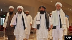 افغان طالبان کا ایک وفد دوحہ میں مذاکرات کے لیے ایک ہوٹل کی لابی میں سے گزر رہا ہے (فائل: 2021)