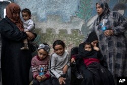 رفح کے ایک ہسپتال میں فلسطینی عورتیں اور بچے اسرائیلی بمباری میں ہلاک ہونے والےاپنے عزیزوں کا سوگ منارہے ہیں، فوٹو اے پی 21 دسمبر 2023