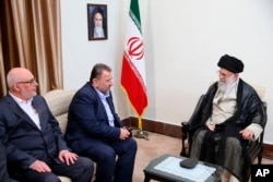 ایران کے اعلیٰ روحانی رہنما آیت اللہ علی خامنہ ای، دائیں طرف، حماس کے نائب سربراہ صالح العاروری(درمیان) کے ساتھ فائل فوٹو۔ بذریعہ اے پی
