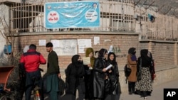 افغان خواتین طالبات کابل، دسمبر 2022میں کابل یونیورسٹی کے باہر کھڑی ہیں. طالبان سیکورٹی فورسز یونیورسٹی کیمپس تک رسائی کو روک دی ہےں۔