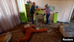 Nhân viên dọn dẹp các mảnh vỡ bên trong tòa nhà của một trường mẫu giáo bị hư hại trong các cuộc tấn công bằng máy bay không người lái của Nga, ở Kyiv, Ukraine ngày 25 tháng 11 năm 2023. 