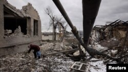 Một người dân dọn dẹp các mảnh vỡ trong sân ngôi nhà người họ hàng đã bị phá hủy trong một cuộc tấn công tên lửa của Nga ở Selydove, gần Avdiivka, Ukraine, ngày 19/2/2024.